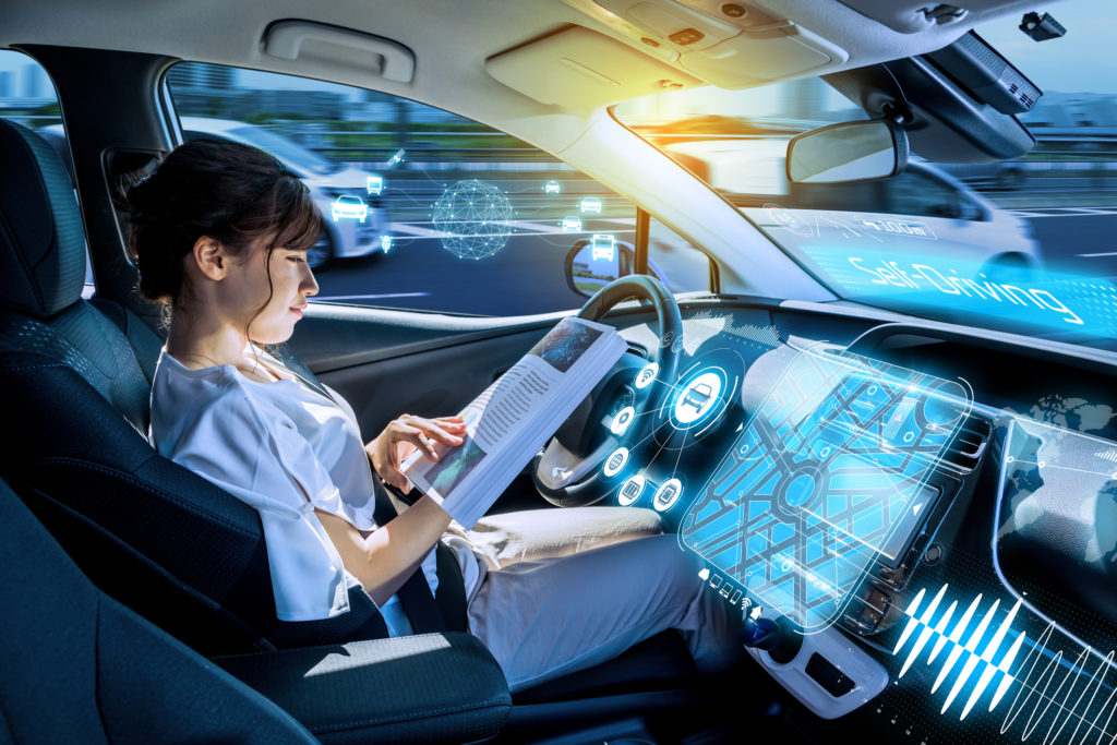 young woman reading a magazine in a autonomous car. driverless car. self-driving vehicle. heads up display. automotive technology.